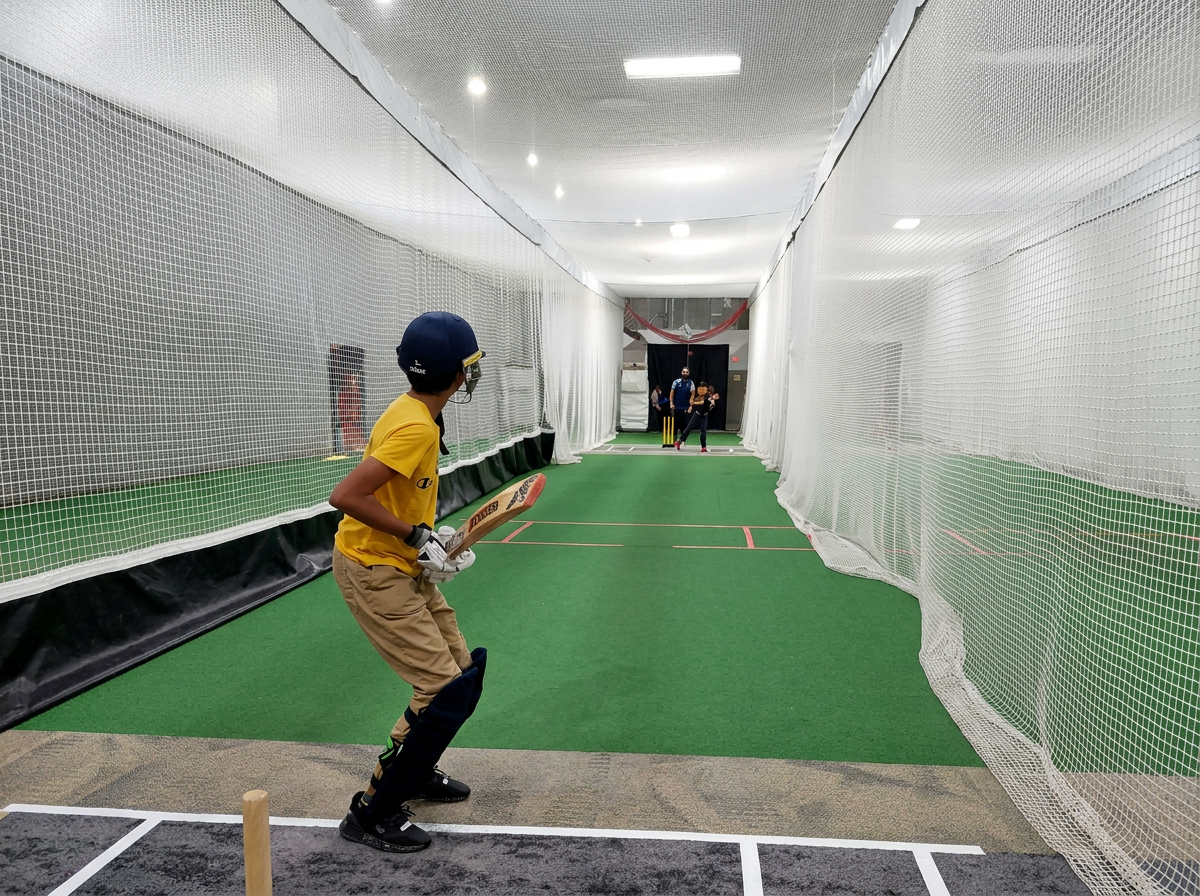 Young player batting in one of the three netted training cages