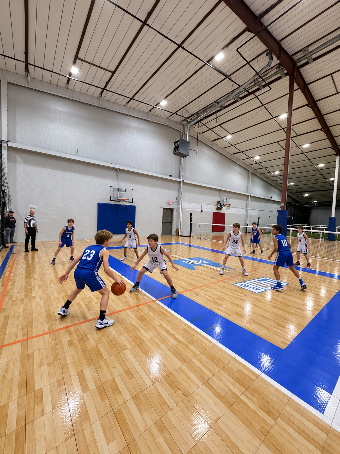 Children playing basketball on the indoor wood hard court during a camp session at PSA Sports Club