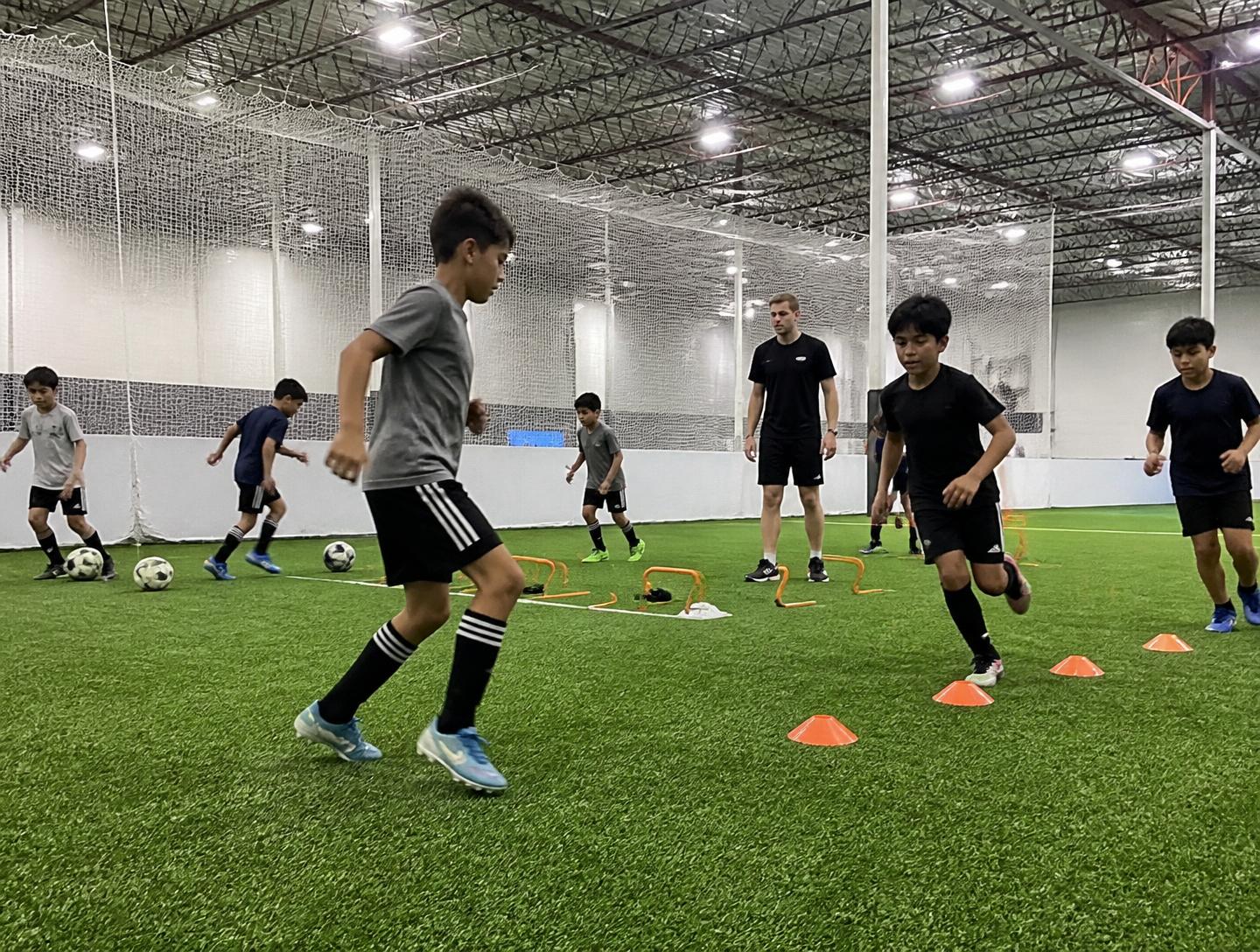 Players working through cone drills in a soccer skills session